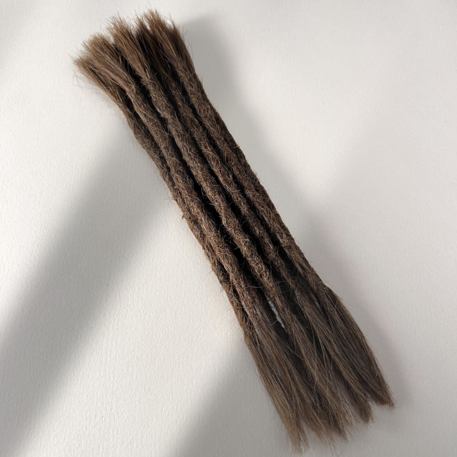 Full view of permanent straight loc extensions with open ends in Medium Brown.