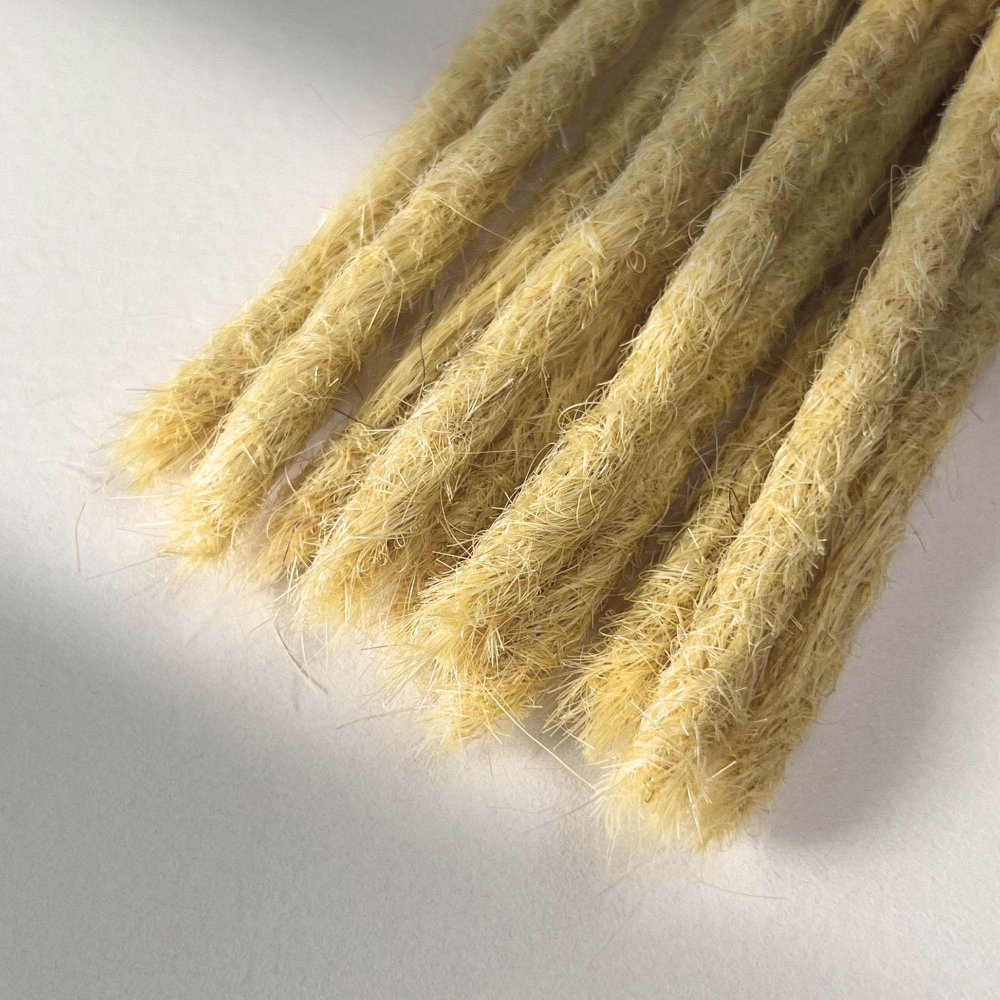 Tip detail of straight loc extensions with blunt ends in Soft Ochre.